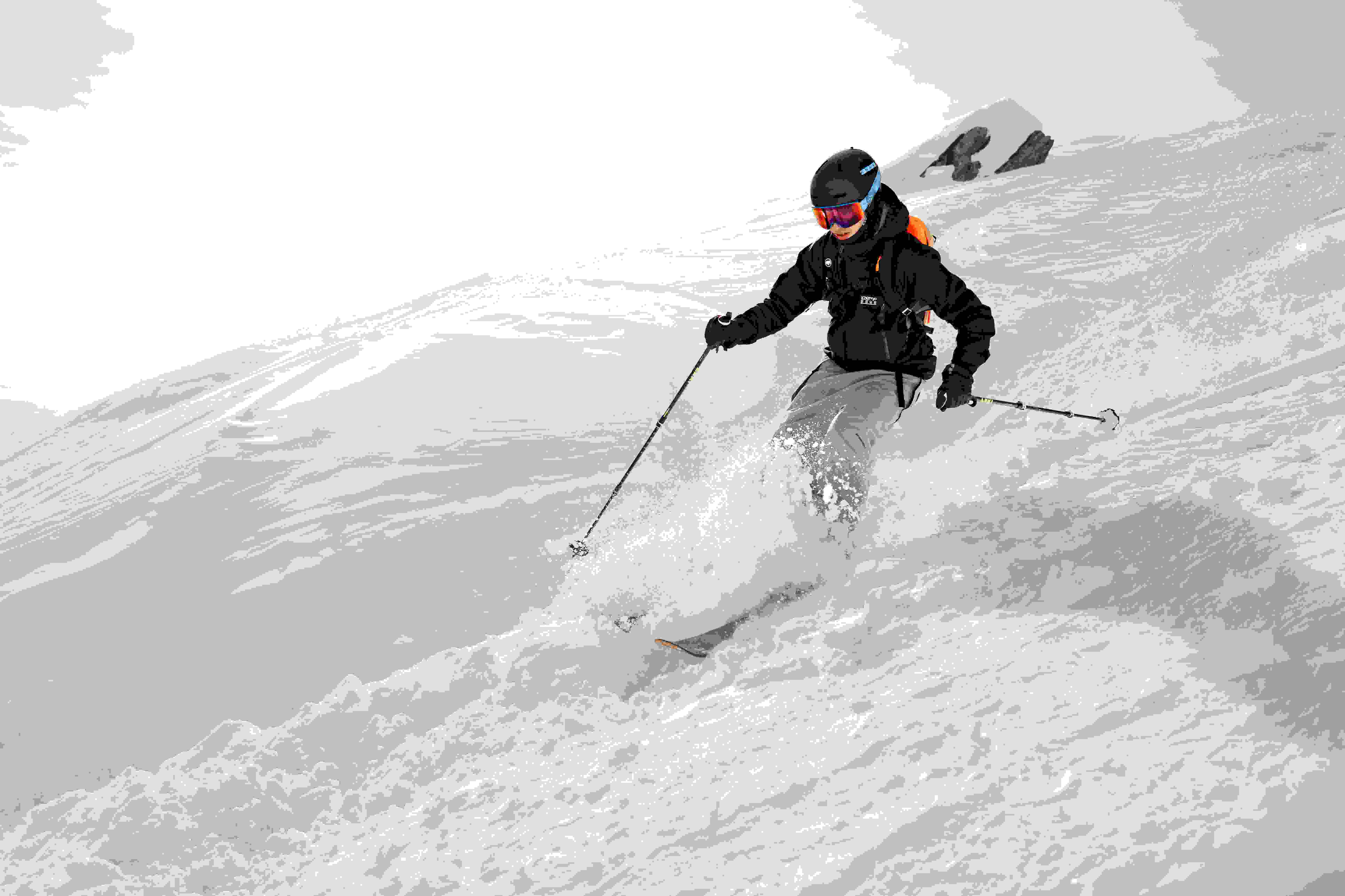 Skier carving through snow in the mountains