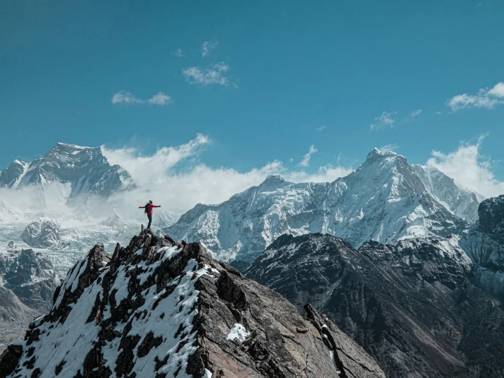 Mountaineer on a ridge surrounded by snowy peaks