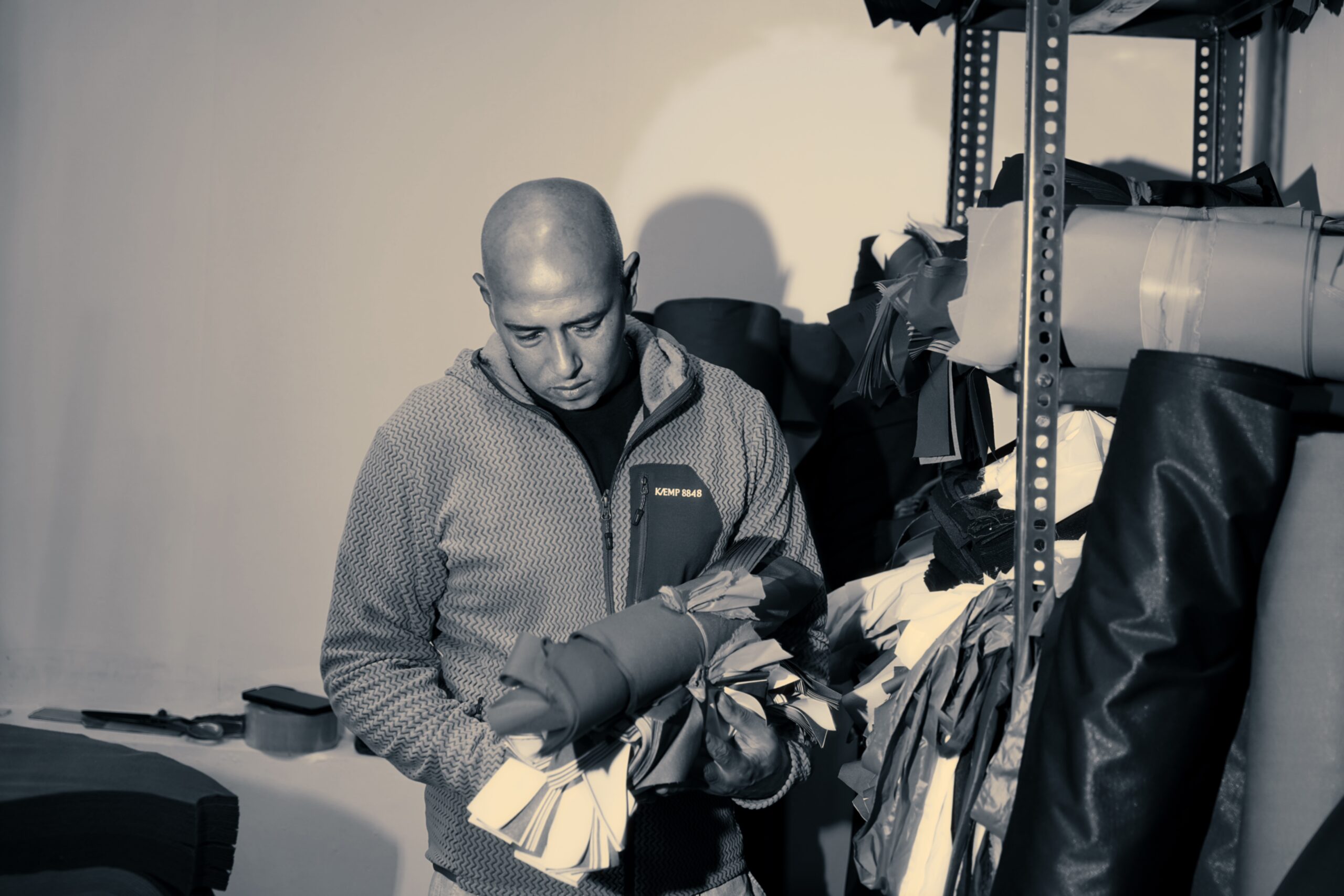 Hands working on a technical jacket in the Kathmandu workshop